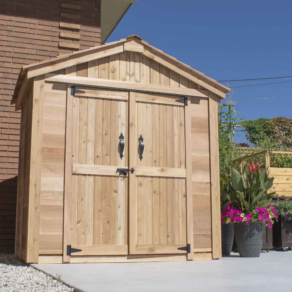 A right-side exterior view of the Outdoor Living Today SpaceMaster 6×4 with Double Door shows the shed closed, sitting on a patio near flower pots and garden plants