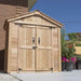 A right-side exterior view of the Outdoor Living Today SpaceMaster 6×4 with Double Door shows the shed closed, sitting on a patio near flower pots and garden plants