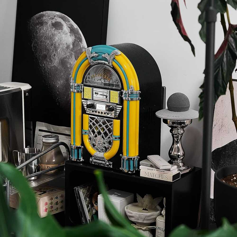 Arkrocket Athena Mini Jukebox Tabletop CD Player Bluetooth Speaker (YellowBlack) is positioned stylishly on a shelf next to books and décor