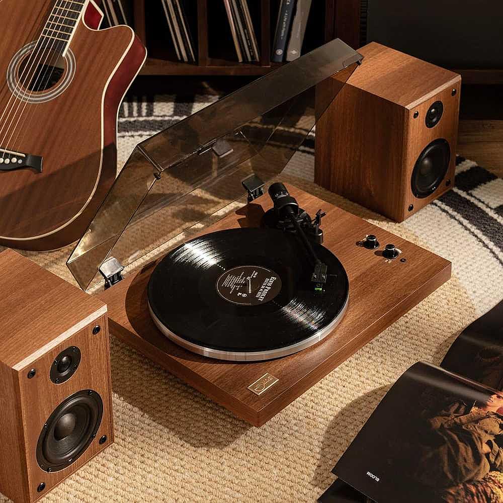 Arkrocket Cassini Bluetooth Vinyl Turntable Record Player 40 Watt Stereo Bookshelf Speakers is playing a vinyl record with two wooden speakers