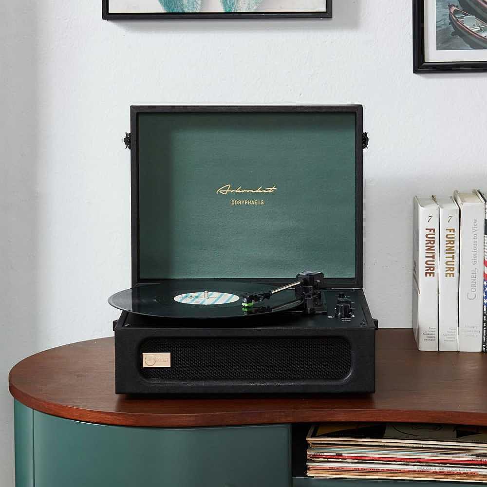 Arkrocket Coryphaeus Bluetooth Turntable Deluxe Edition Record Player (BlackGreen) is seen placed on a wooden cabinet surrounded by books