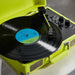 Arkrocket Curiosity Suitcase Bluetooth Turntable (Neon Yellow) is spinning a record with the tonearm in place