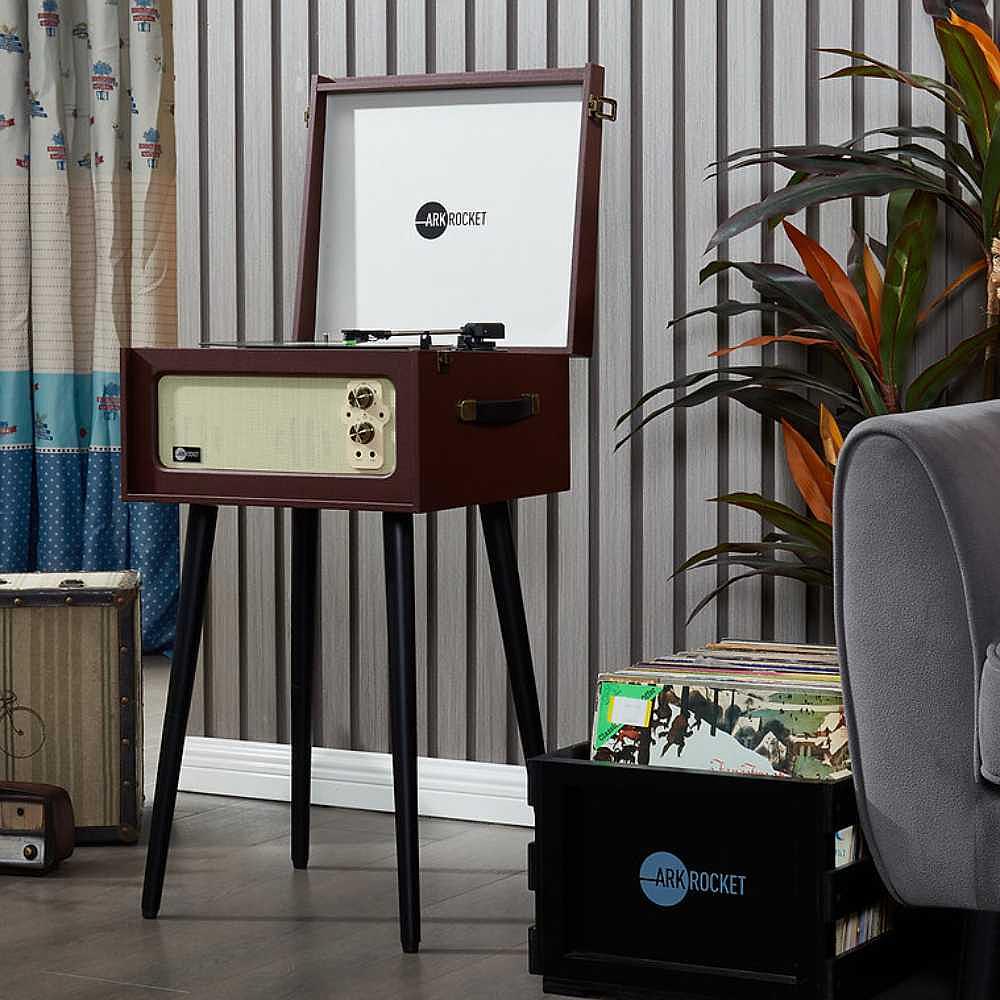 Arkrocket Discovery II Console 3-Speed Bluetooth Record Player with Legs (Brown) is open and displayed in a modern room with plants