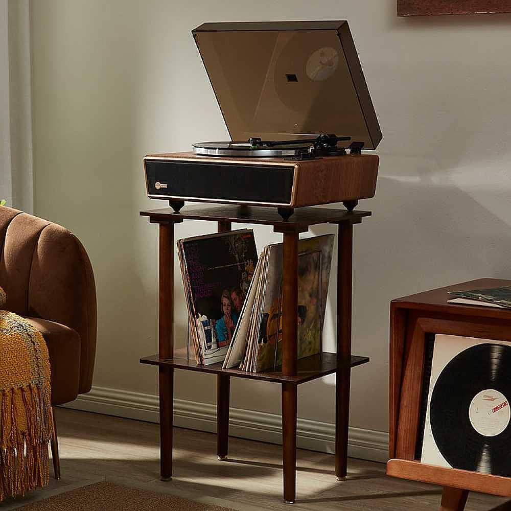 Arkrocket Huygens Bluetooth Turntable with Built-in Speakers (Walnut) on a wooden stand with vinyl records stored underneath