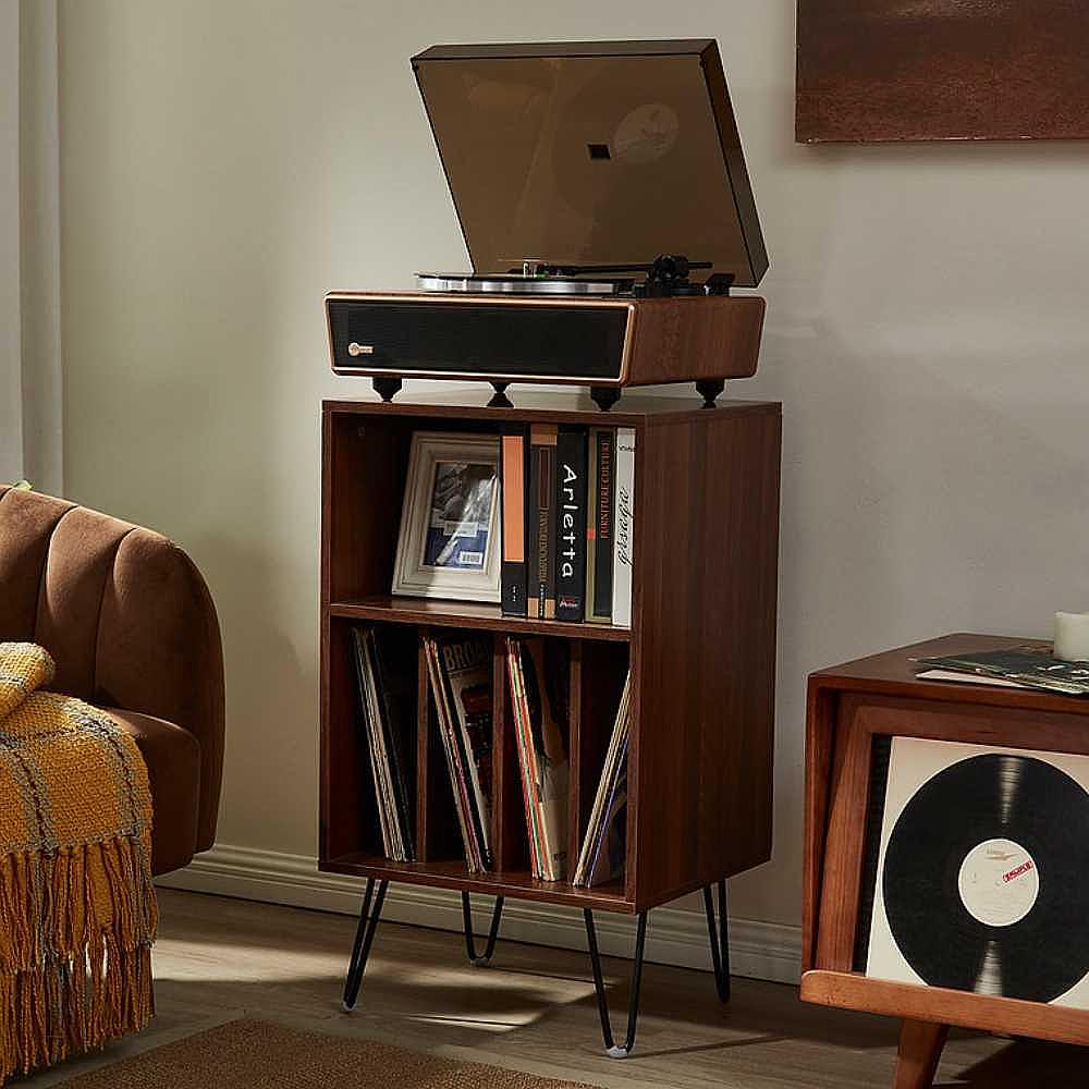 Arkrocket Huygens Bluetooth Turntable with Built-in Speakers (Walnut) placed on top of a wooden record storage unit in a living room