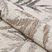 A rolled edge of the Couristan Charm Indoor/Outdoor Rug - Kimberly/Naturals displays the thick, woven texture and detailed leaf pattern