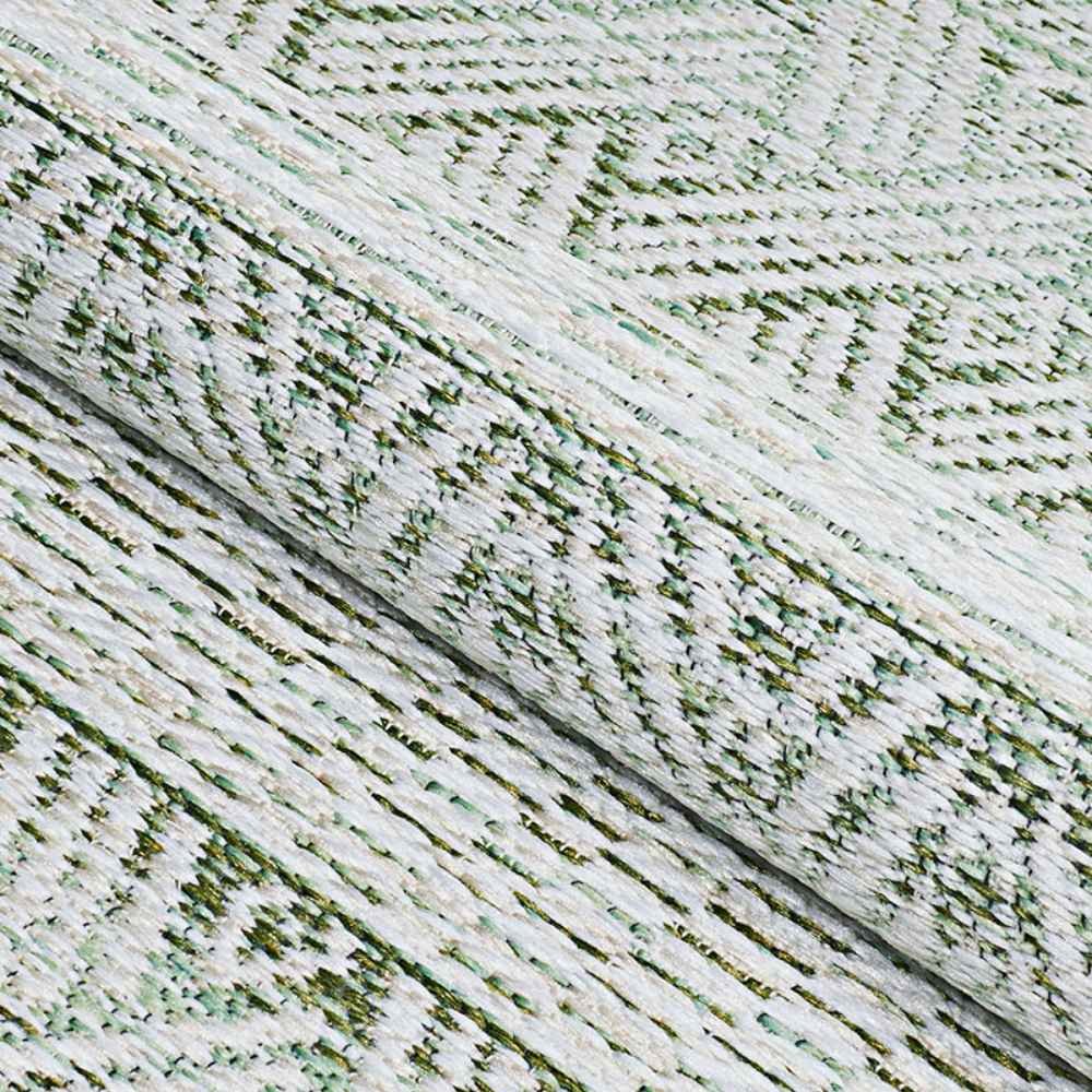 A rolled view of the Couristan Cape Indoor/Outdoor Rug - Gables/Palm highlights its thick texture and detailed geometric pattern in green and ivory tones