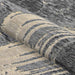 A rolled view of the Couristan Castille Indoor/Outdoor Rug - Canvas/Glacier displays its tightly woven structure and modern brushstroke design