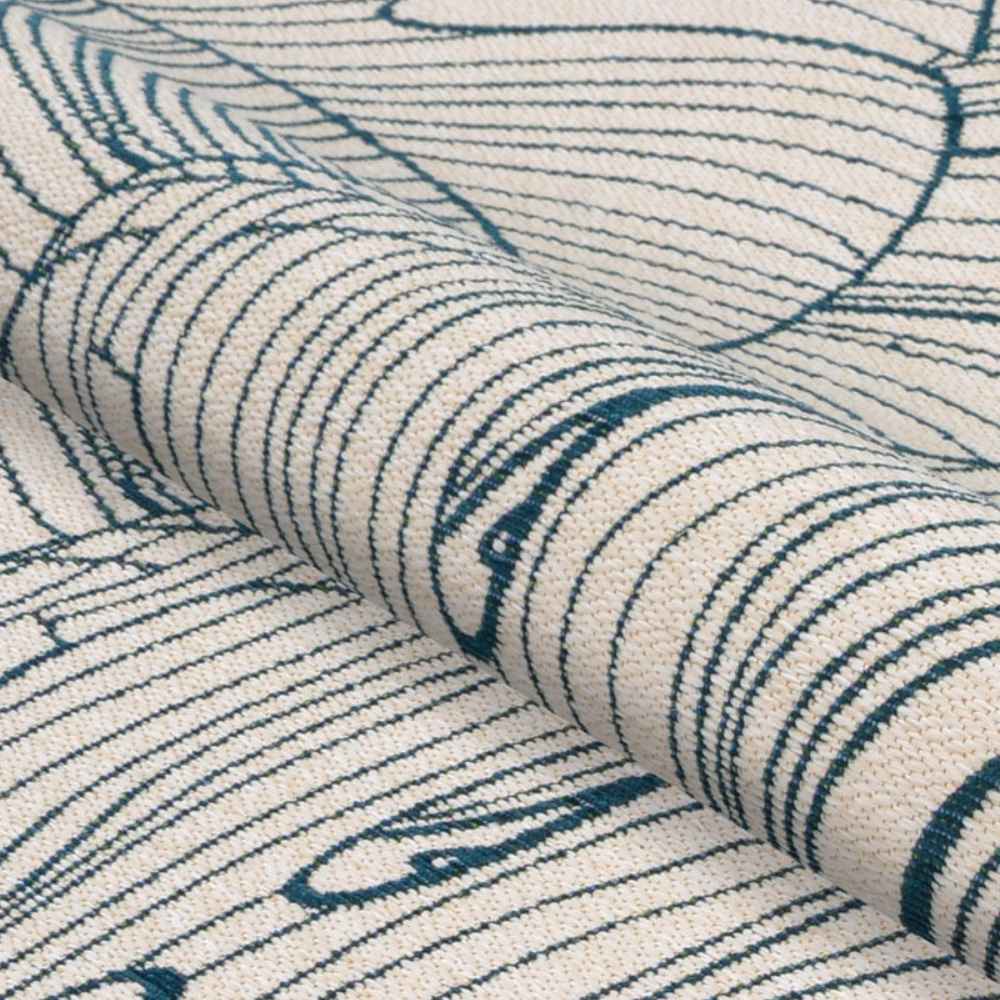 A rolled view of the Couristan Castille Indoor/Outdoor Rug - Palma/Petrol showcases the soft, durable weave and flowing leaf lines