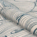 A rolled view of the Couristan Castille Indoor/Outdoor Rug - Palma/Petrol showcases the soft, durable weave and flowing leaf lines