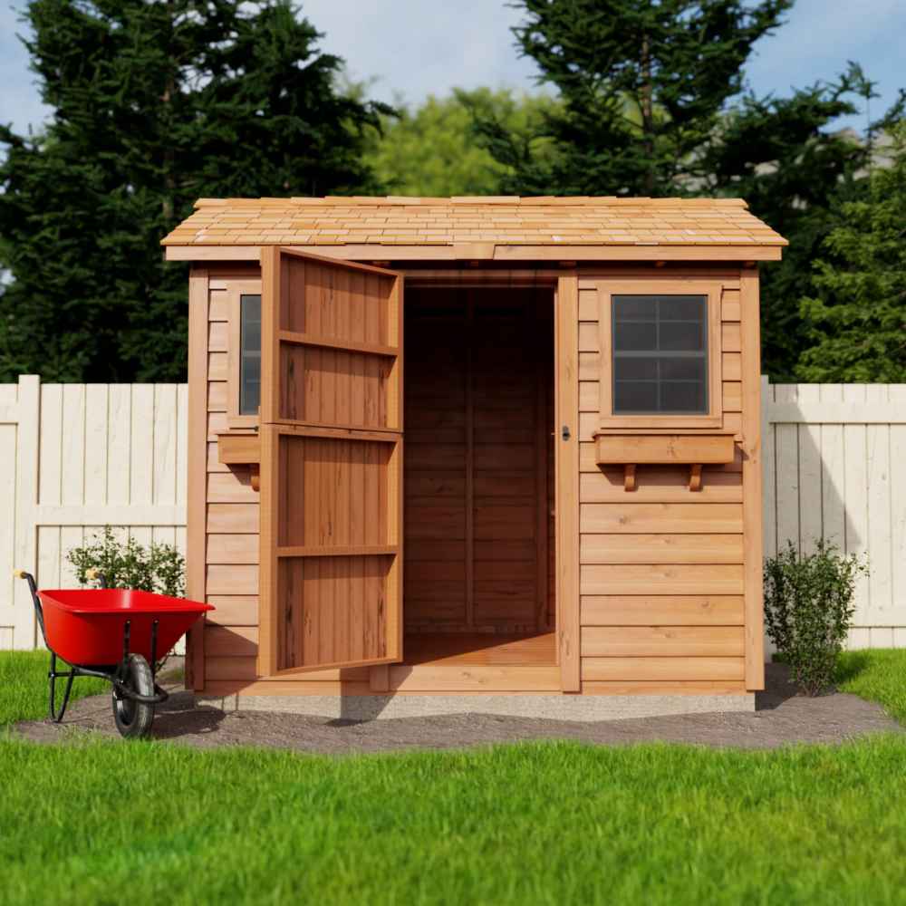 A rustic garden shed with one open door, cedar roof, and a red wheelbarrow beside it sits on a lawn, representing the Outdoor Living Today 9×6 Cabana Garden Shed
