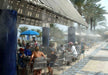 A shaded poolside dining area is cooled by the Aeromist Pinnacle 1000 PSI Misting System creating a visible mist around guests
