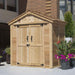 A side-angled view of a closed Outdoor Living Today SpaceMaster 6×4 with Double Door displays its natural wood exterior and black metal door handles next to flower pots
