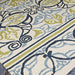 A side angle captures the intricate blue and green motifs of the Couristan Covington Indoor/Outdoor Rug - Pegasus/Ivory-Navy-Lime on a light ivory base