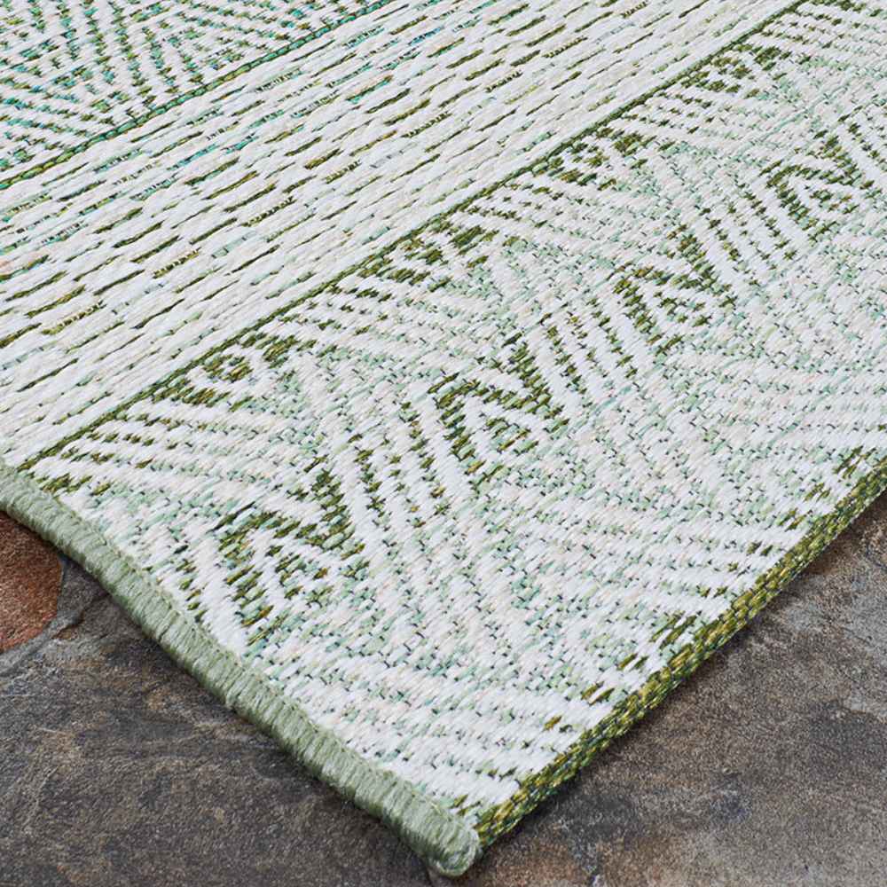 A side angle of the Couristan Cape Indoor/Outdoor Rug - Gables/Palm showcases the tightly bound edge and detailed craftsmanship of its design