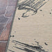 A side angle of the Couristan Castille Indoor/Outdoor Rug - Canvas/Glacier shows its clean edge against stone flooring