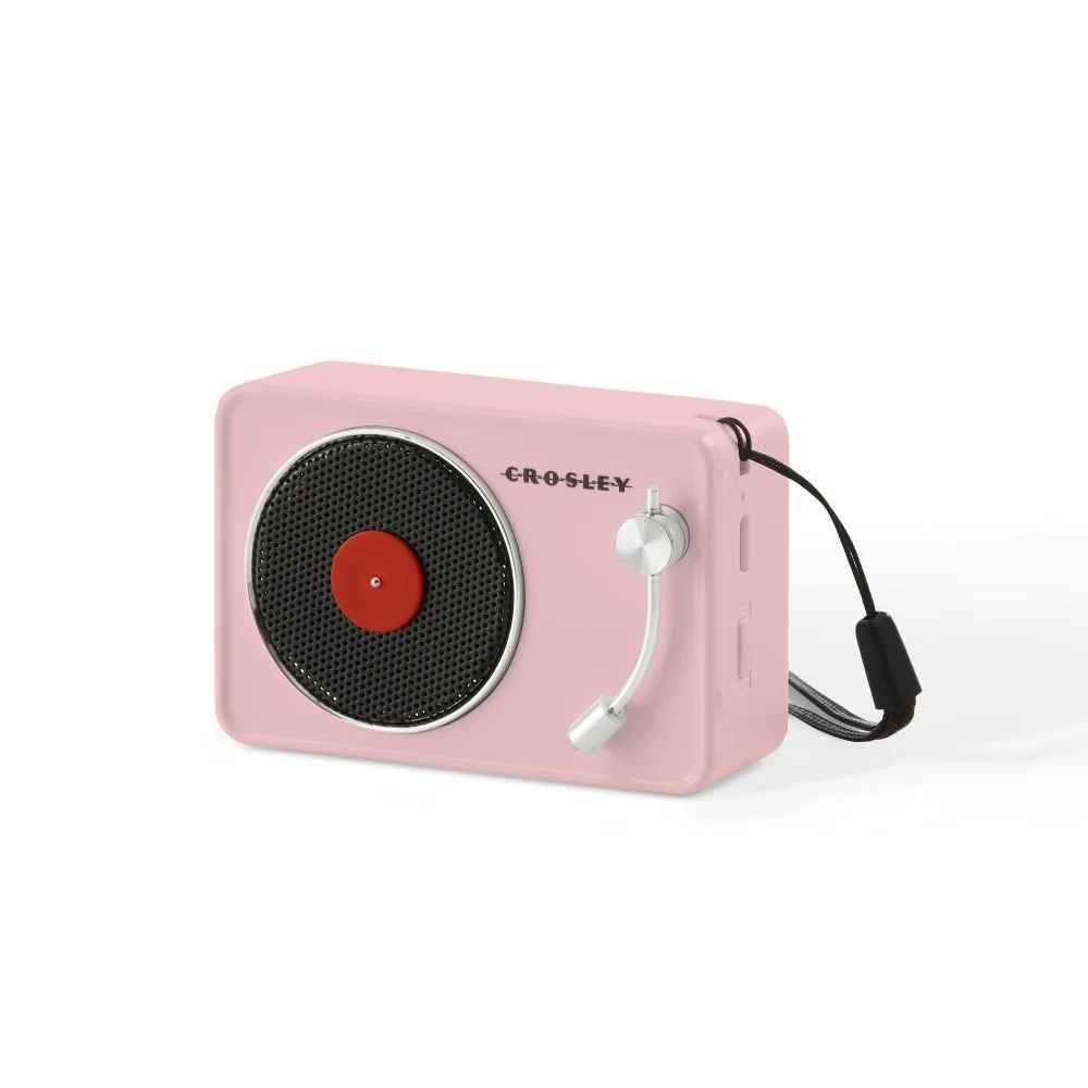 A side angle of the Crosley Mini Turntable Bluetooth Speaker - Pink shows its strap and button layout for portability