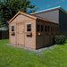 A side angle of the Outdoor Living Today 12×16 Sunshed Garden Shed with many windows, flower boxes, and a neatly trimmed yard