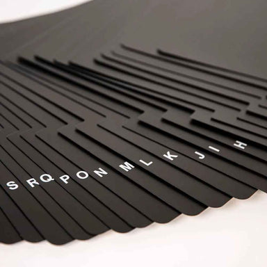 A side view of the Crosley A-Z Vinyl Dividers - Black, showcasing their staggered tabs with white lettering