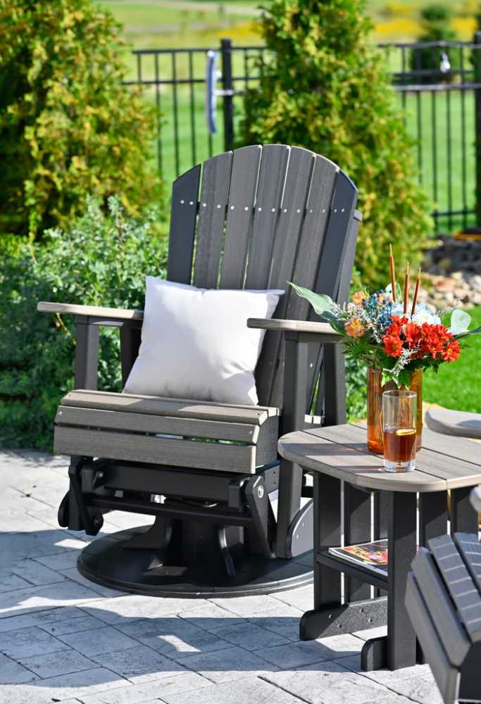 A sleek gray Adirondack glider chair with a white LuxCraft 15 Toss Pillow