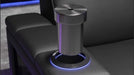 A sleek metal accessory is inserted into the armrest of the Valencia Monza Pillow Top Carbon Fiber Home Theater Seating