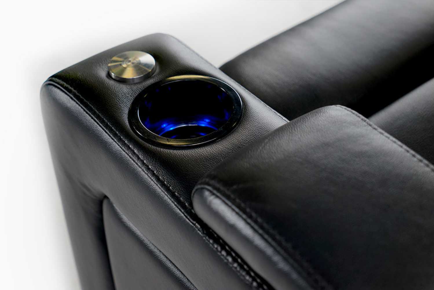 A sleek midnight black leather armrest of the Valencia Oslo Modern Home Theater Seating, featuring a glowing LED cupholder and a metallic control button