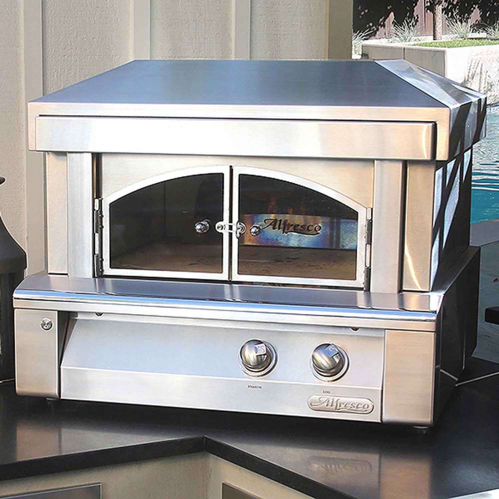 A sleek stainless steel Alfresco Grills 30 Pizza Oven Plus - Countertop Model is installed on a countertop, glowing warmly with fire inside