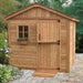 A small wooden shed with a pitched roof, a window box of flowers, and a ramp at the door, showcasing the Outdoor Living Today 8×8 Gardener Shed