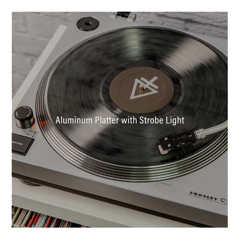 A spinning vinyl is captured on the Crosley K100A Record Player with S100 Speakers - Silver, emphasizing its aluminum platter and strobe light