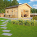A welcoming garden patio setup complements the GardenHouse24 USA Astrid 70 Garden Room, which opens to a sunny backyard and lush landscaping