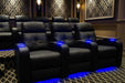 A theater-style room showcases multiple Valencia Verona Home Theater Seating chairs with glowing LED cupholders and under-seat lighting