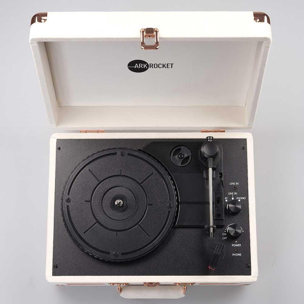 A top-down view of the Arkrocket Curiosity Suitcase Bluetooth Turntable (Cream Velvet) shows the turntable’s minimalist design with visible dials and a tonearm