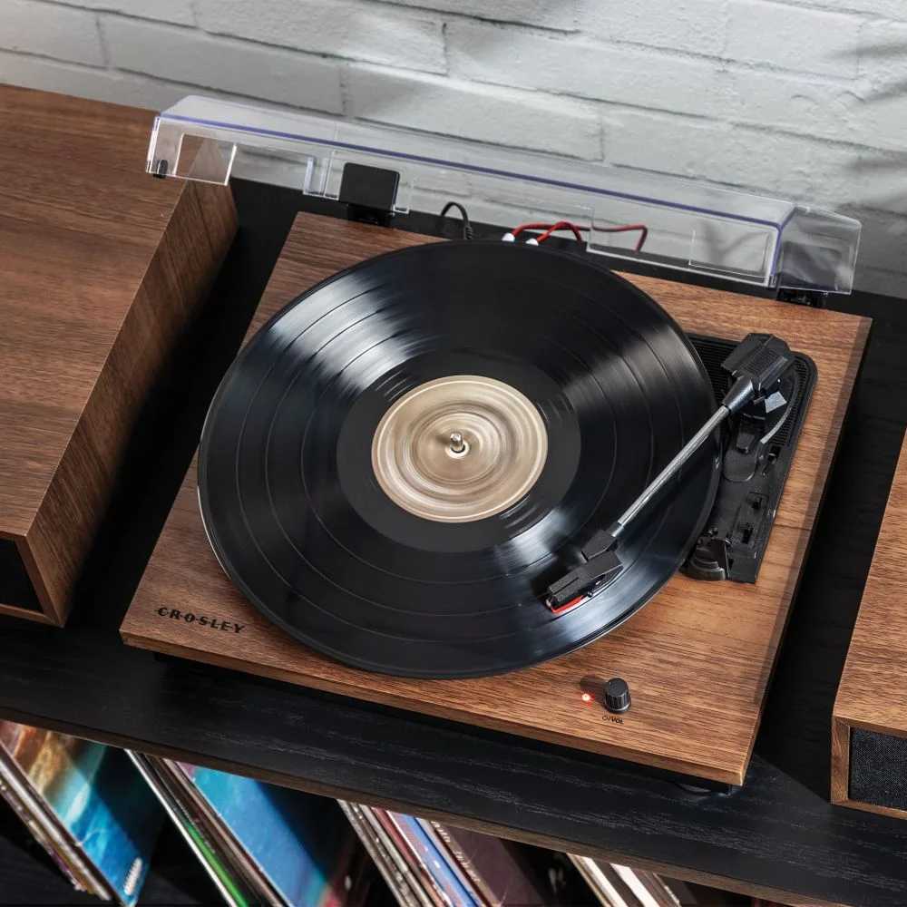 A top-down view of the Crosley Riff Record Player With Speakers - Walnut highlights the vinyl record spinning on its turntable and the minimalistic design