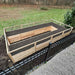 A top view shows the Outdoor Living Today 8×16 Raised Garden Bed filled with soil, framed by a black metal fence and surrounded by grass