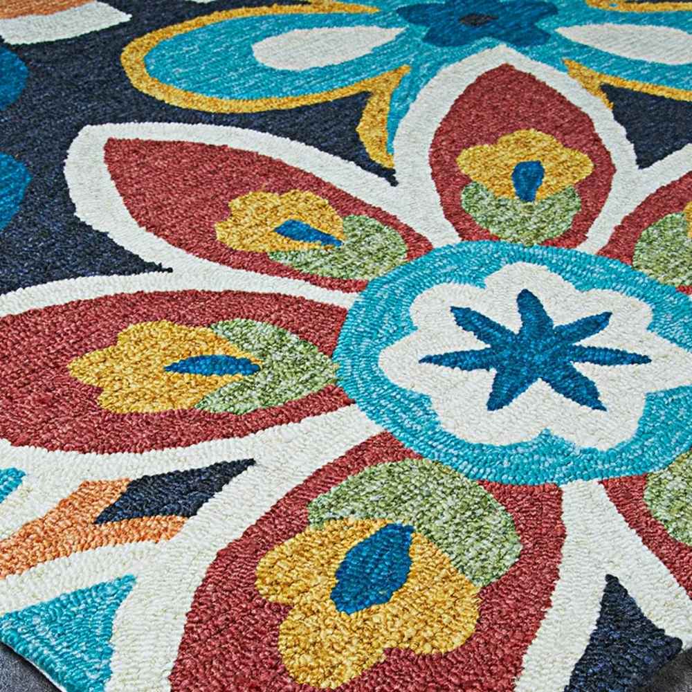 A vibrant floral design with red, blue, and green petals pops against a dark background on the Couristan Covington Indoor/Outdoor Rug - Geranium/Navy-Multi