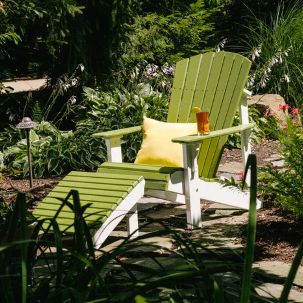 A vibrant green and white Adirondack chair with a matching ottoman complemented by a yellow LuxCraft 15 Toss Pillow