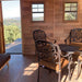 A view from inside the Outdoor Living Today 12×12 Sunshed Garden Shed shows an open door, two small windows, and a cozy setup with decorative chairs