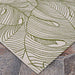 A wide-angle view of the Couristan Castille Indoor/Outdoor Rug - Palma/Fern displays its bold green leaf design sprawling across a white background