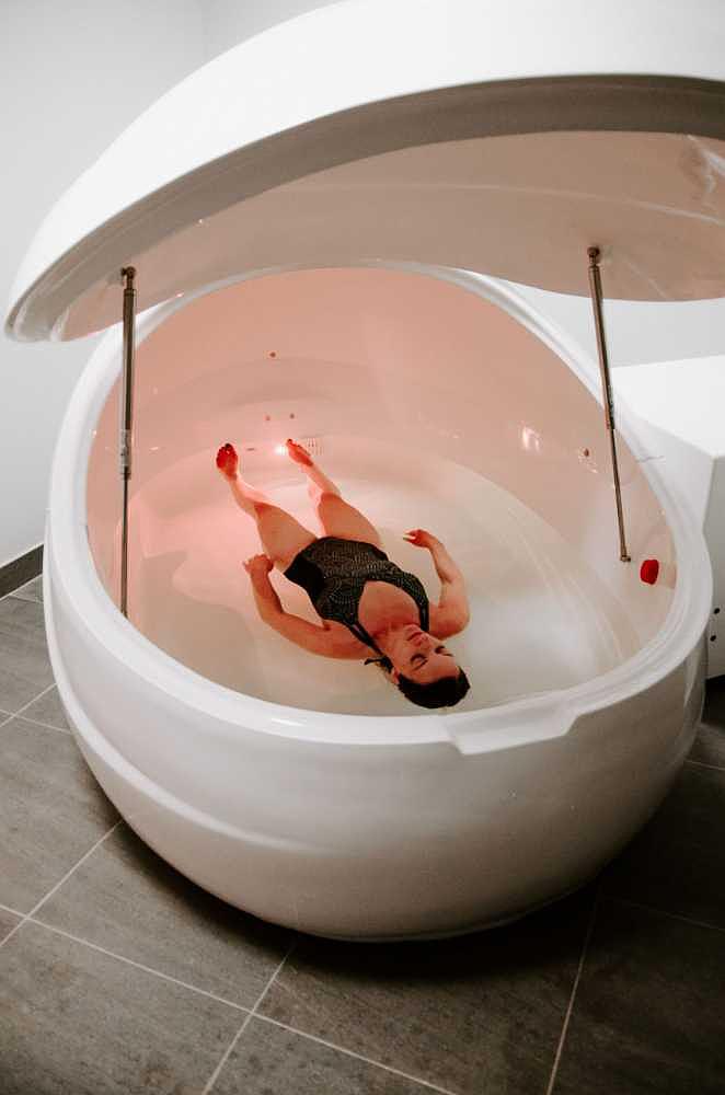 A woman floats effortlessly inside the Dreampod V2 Float Pod