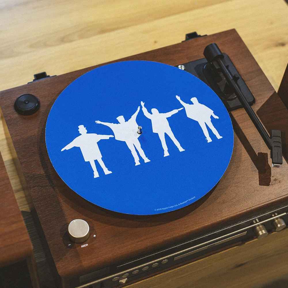 A wooden turntable with a mounted bright blue Crosley The BEATLES Platter Pad - HELP showing The Beatles' white silhouettes in Help! pose