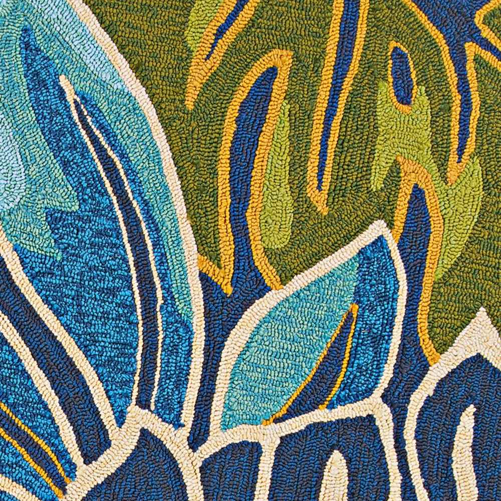 A zoomed-in section of the Couristan Covington Indoor/Outdoor Rug - Areca Palms/Brown-Forest Green displays large, overlapping tropical leaves in aqua blue, yellow, and forest green