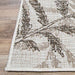 A zoomed-in view shows the neat edge stitching and brown-toned leaf design of the Couristan Charm Indoor/Outdoor Rug - Kimberly/Naturals against a wood floor