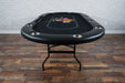 BBO Poker Tables Aces Pro Plus Poker Table is shown folded out in a room with wooden flooring and a brick wall