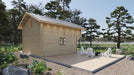Back view of Sawmill Structures The Northwood Grand DD 70mm Garden Room reveals a serene outdoor patio with white chairs and a fire pit surrounded by trees