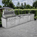 Backyard view of Sunstone French Quarter 13ft 7in Outdoor Kitchen Island Package with open grill and full stainless steel kitchen layout