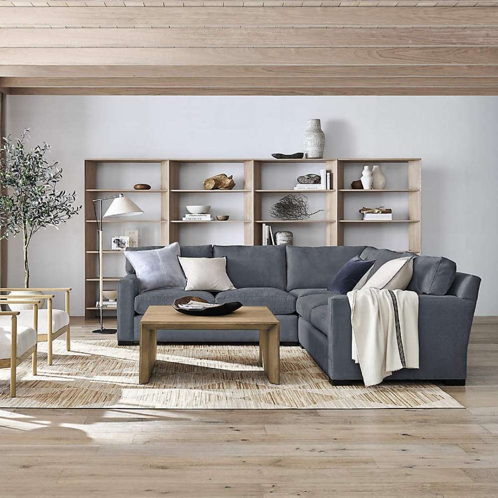 Behind a large sectional sofa, Crate & Barrel Terrazza Natural Oak 5-Shelf Bookcases, Set of 2 creates a stylish room divider with open storage and decor