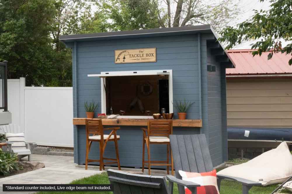 Blue-painted Sawmill Structures The Lakeside Versa Cabana 67 Garden Room features a raised counter and bar stools under a shaded backyard setting