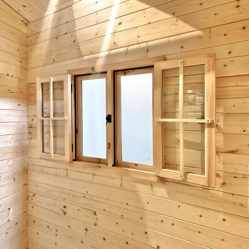 Interior close-up of wooden windows with frosted center panes and open grid shutters inside the BlueWater Bungalow 160.