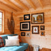 Cozy lounge corner in the BlueWater Loft 160 38mm featuring a teal sofa, rustic gallery wall, snowshoes, and exposed ceiling beams.