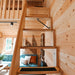 Wooden staircase with black traction pads leading to the upper loft of the BlueWater Loft 160 38mm above a teal sofa.